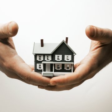 hands holding miniature house home design software